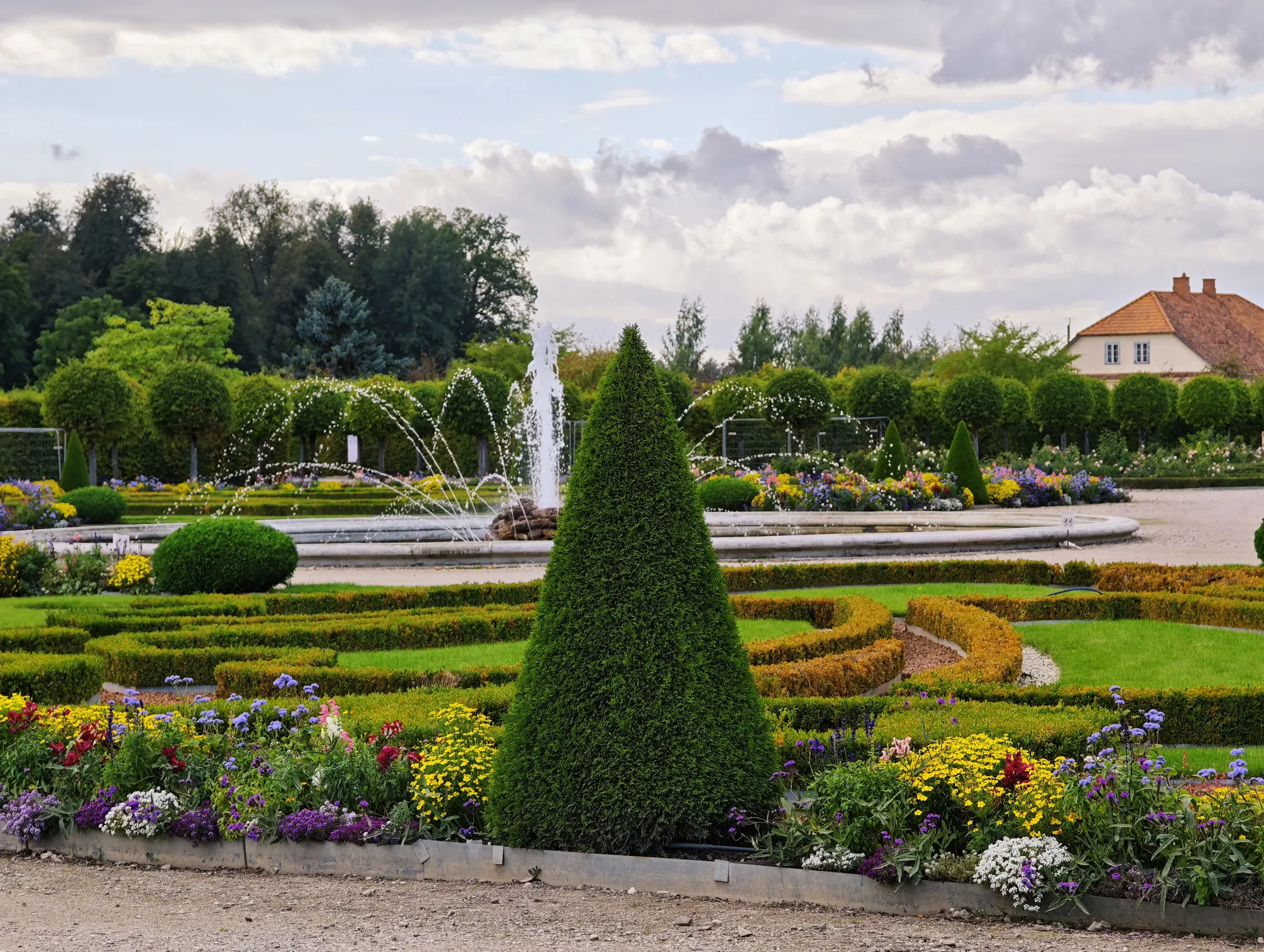 The formal French garden at Rundāle Palace, with clipped cones of yew, flower beds and a fountain.