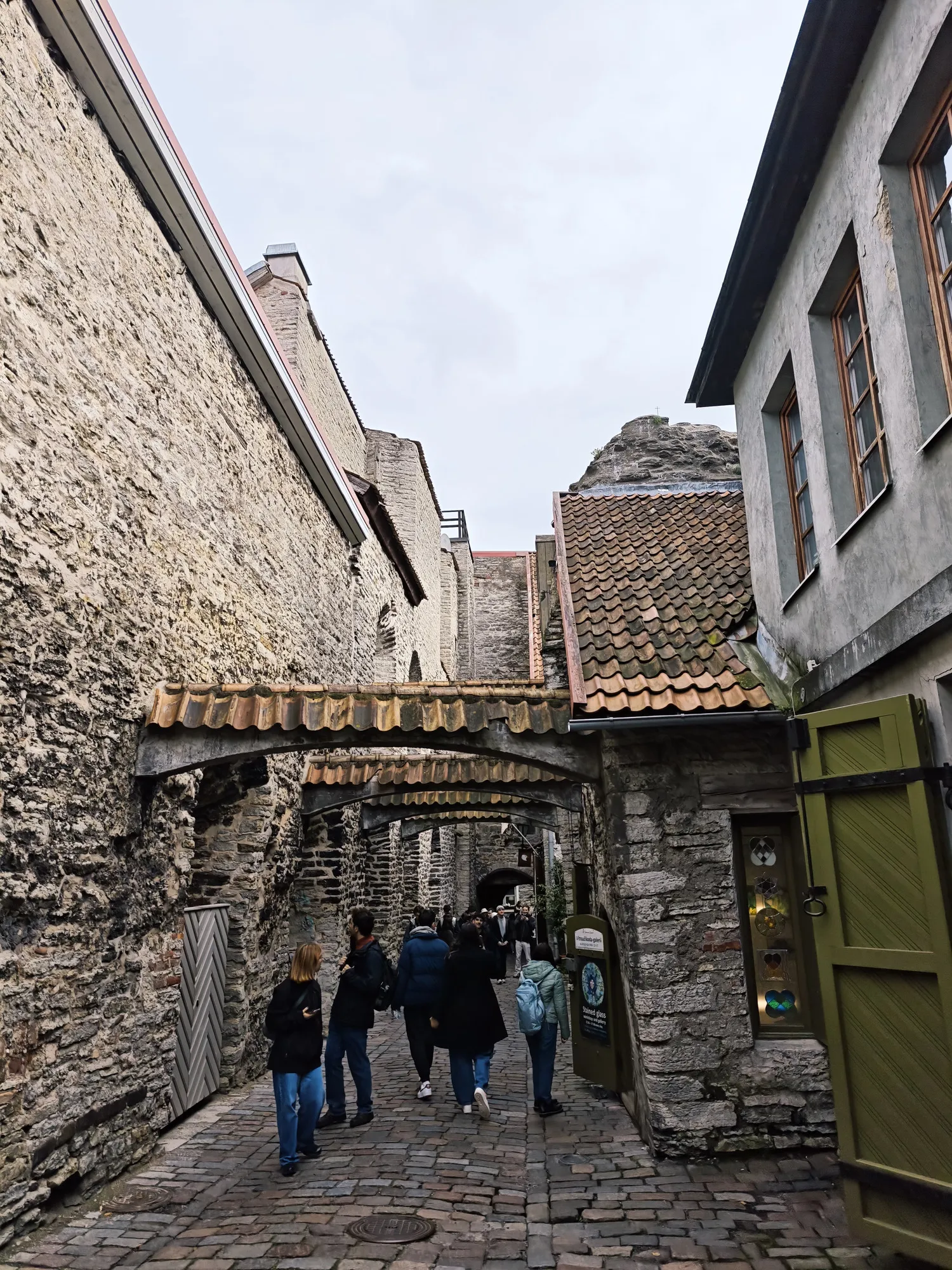 St Catherine's Passage in Tallinn's old town, a narrow medieval lane crossed by stone buttresses.