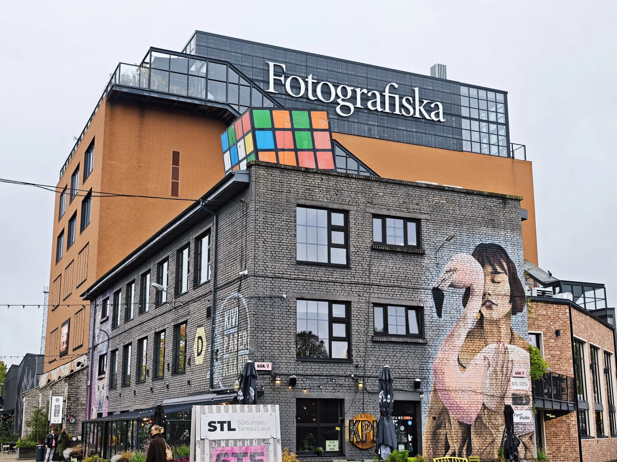 The Fotografiska building in Tallinn's Telliskivi district, an old brick factory with a mural of a woman and a flamingo.