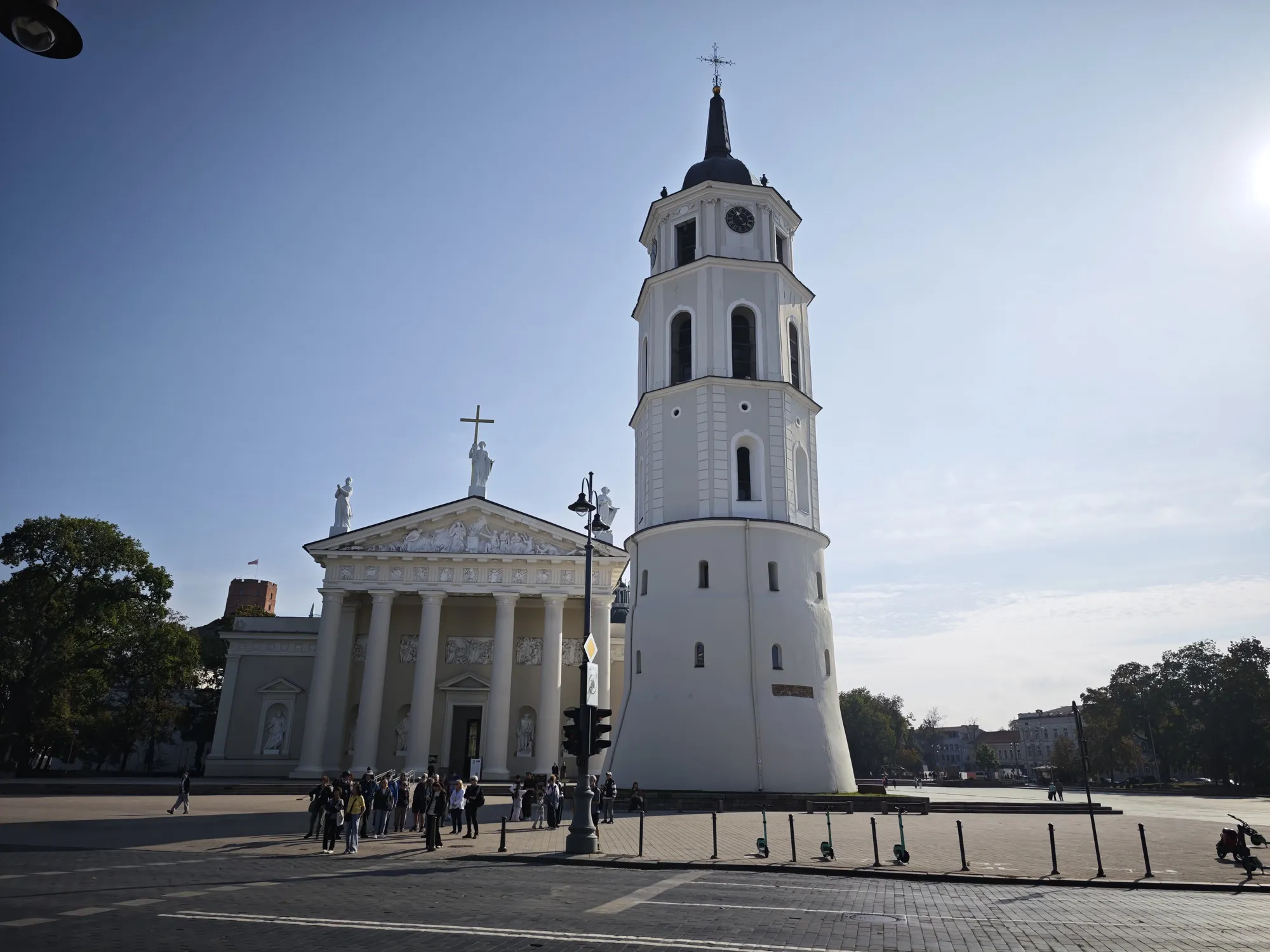 Vilnius Cathedral and its detached white bell tower, under a clear morning sky.
