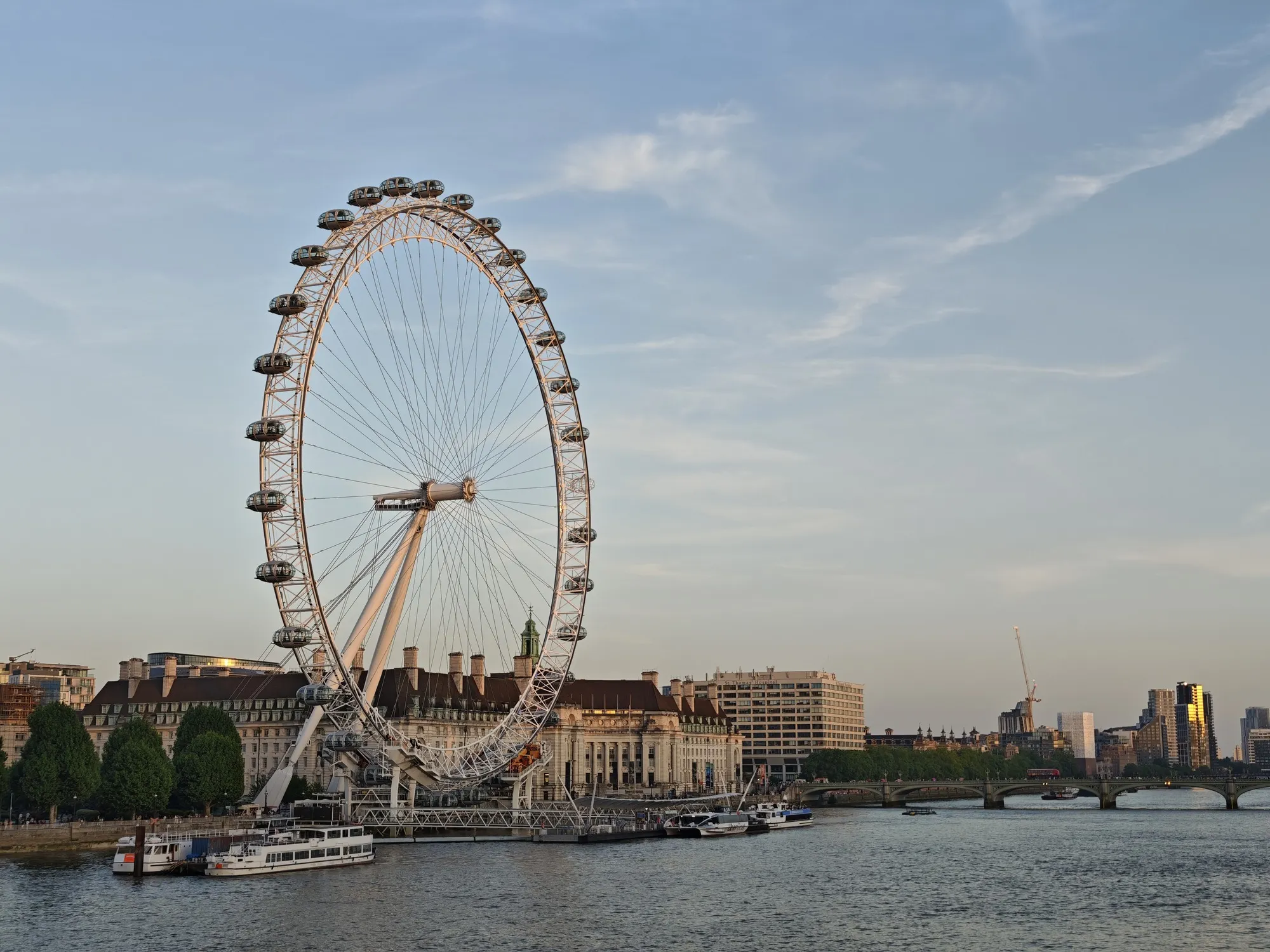 The London Eye gone quiet over the Thames at dusk, a minute before the lights came up.