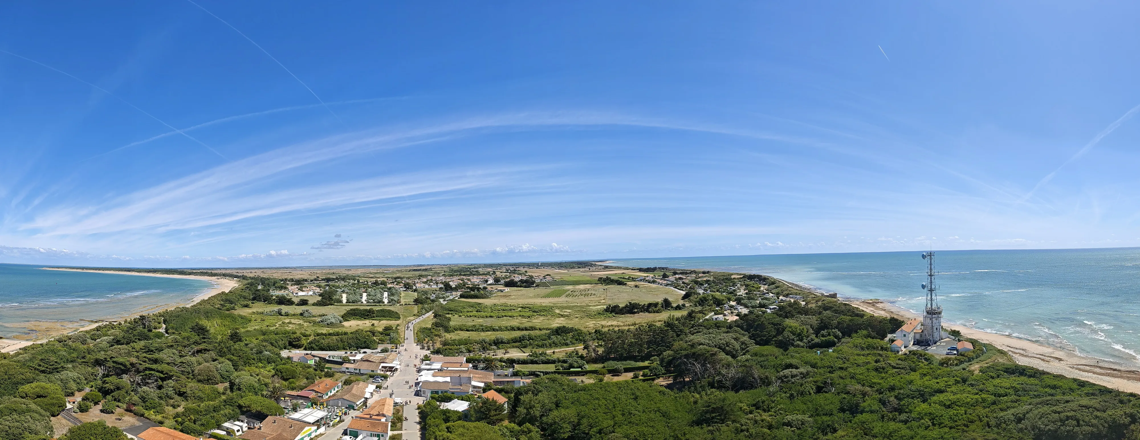 The western tip of Île de Ré from the top of the Phare des Baleines, 257 steps up: vineyards, scrub, and the sea on both sides at once.