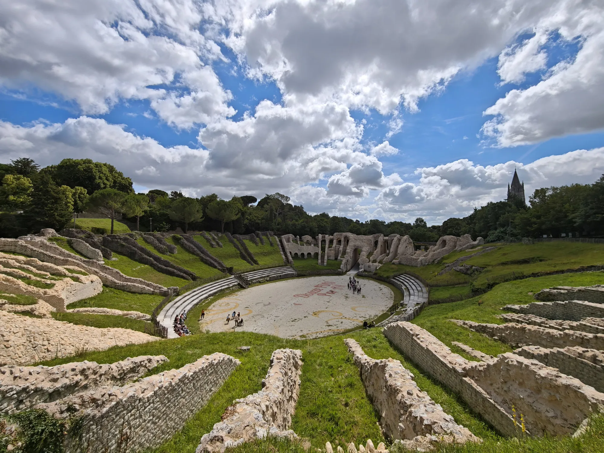 The Gallo-Roman amphitheatre at Saintes, its stone tiers gone to grass, all but empty on a weekday morning.